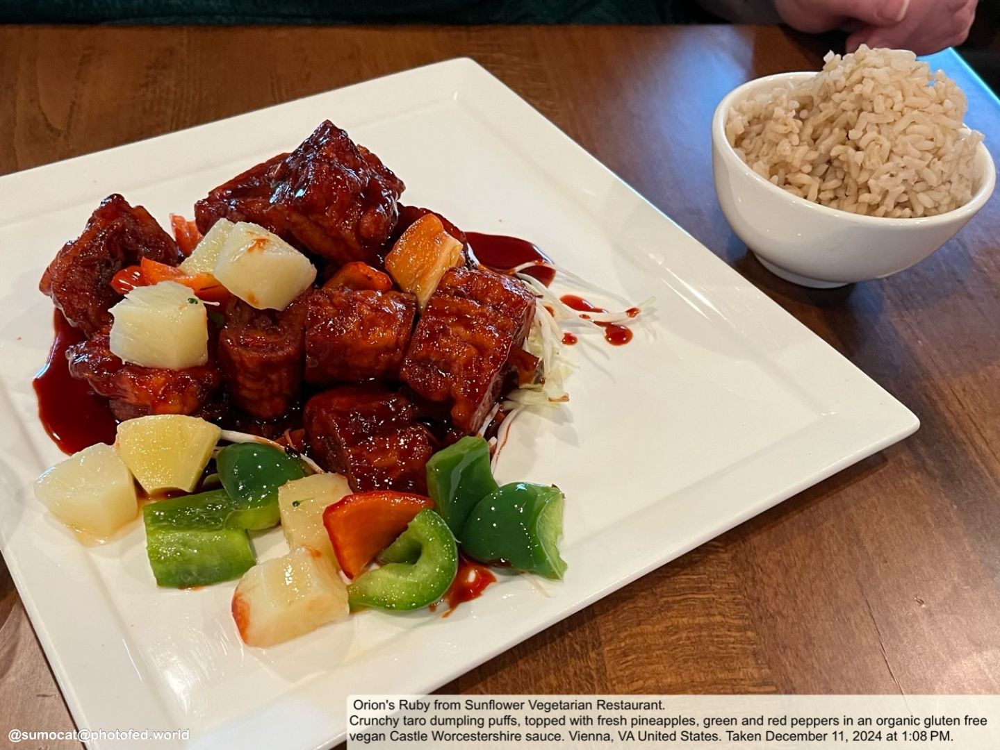 Red glazed, crunchy taro dumpling puffs, topped with fresh pineapples, green and red peppers in an organic gluten free vegan Castle Worcestershire sauce with a side of brown rice. Vienna, VA United States. Taken December 11, 2024 at 1:08 PM.